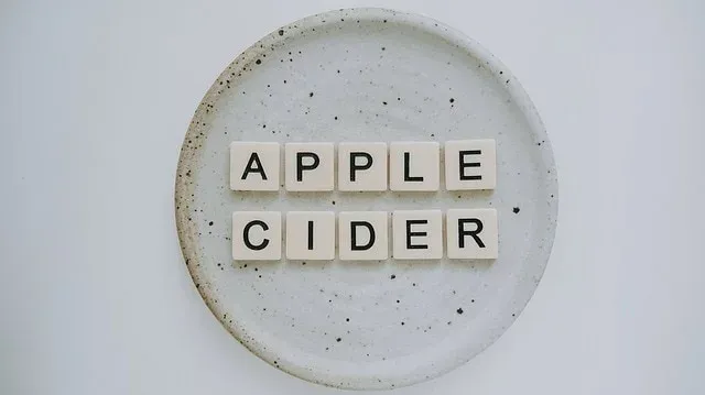 Literowe kostki układają napis APPLE CIDER na jasnym talerzu