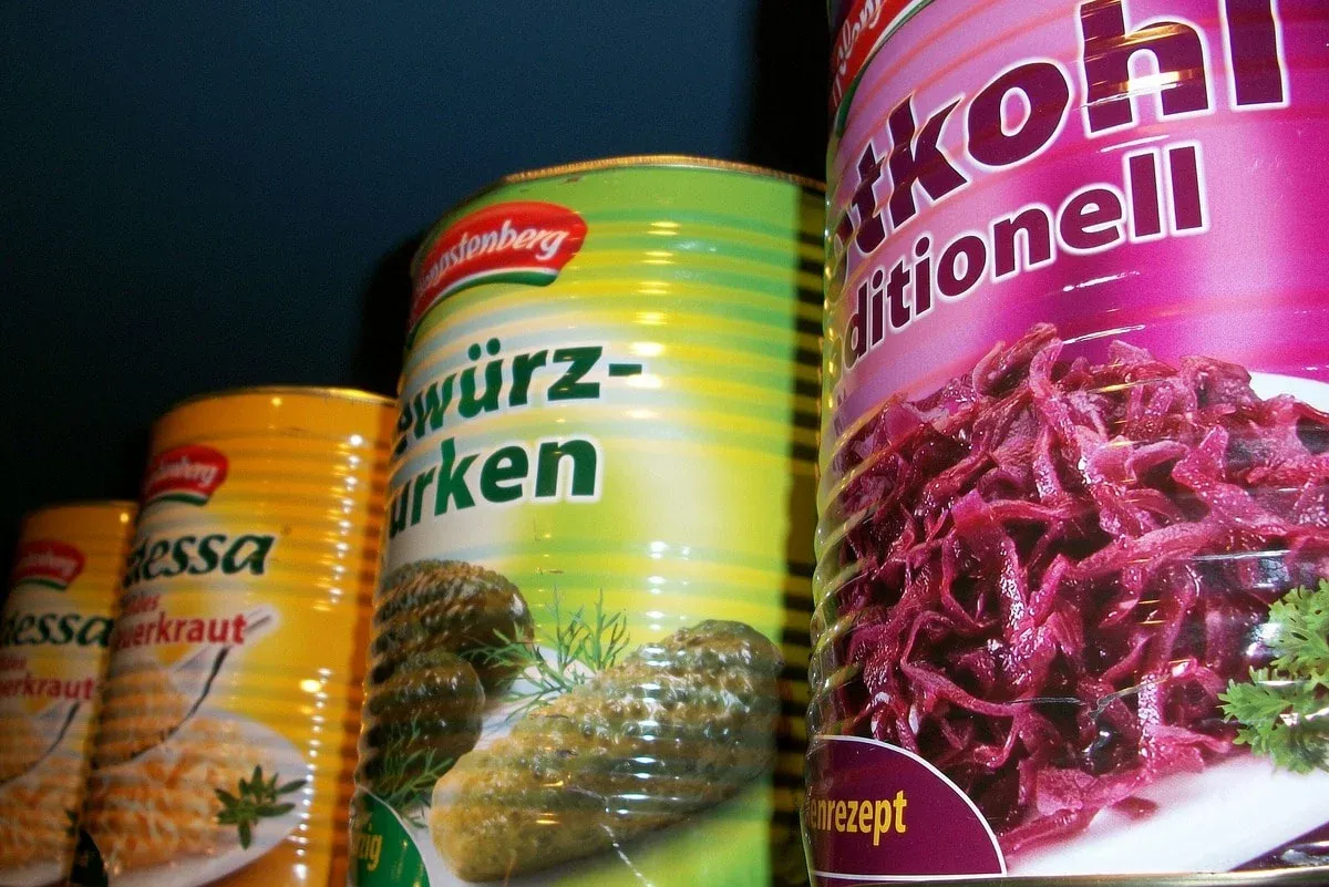 Row of canned red cabbage, pickles and sauerkraut with colorful labels
